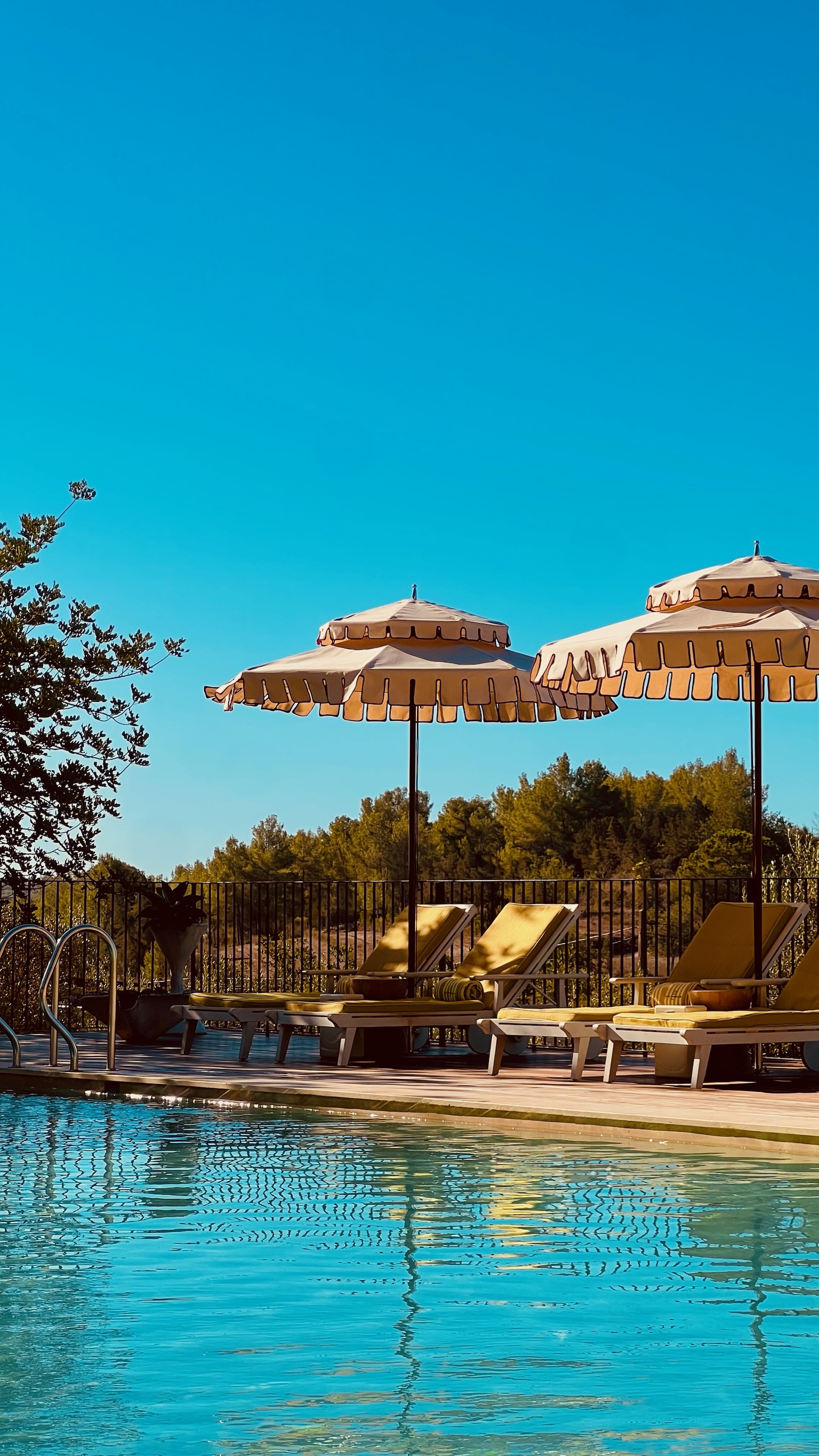 Pool with fringed parasols and loungers at the former Cas Gasi estate, now Soho Farmhouse Ibiza, Santa Gertrudis