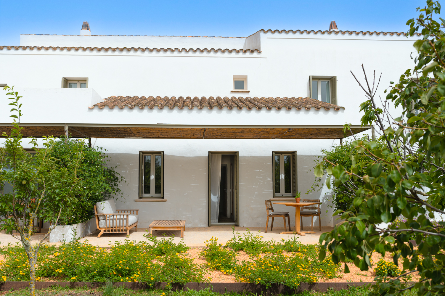Whitewashed farm buildings of the Torralbenc estate above vineyard rows near Alaior, Menorca