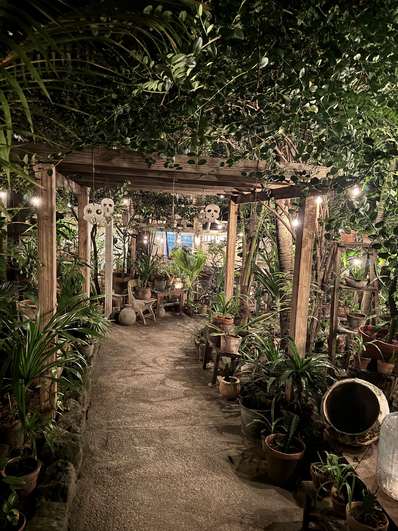 The candlelit, plant-draped garden courtyard at night at Posada Margherita, Tulum